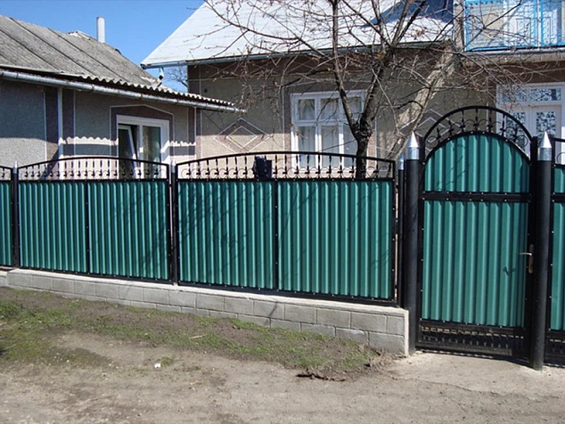 Зеленый кованый забор из профнастила для загородного дома